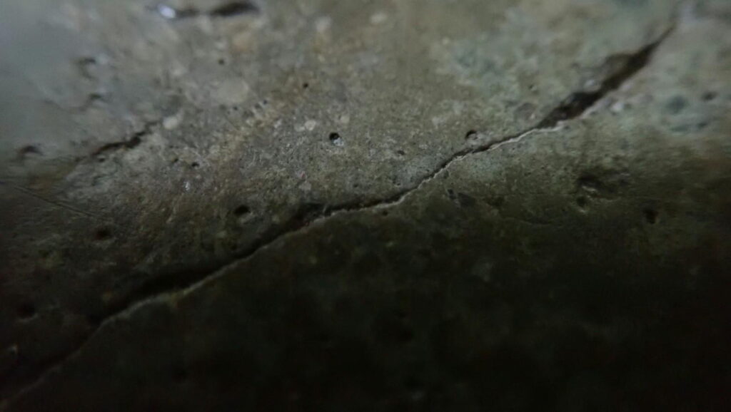 Close-up view of a cracked concrete floor surface showing visible damage before repair need floor repair