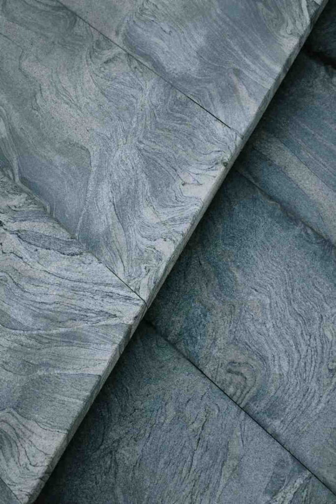 Grey stone-look luxury vinyl flooring with natural swirling patterns.