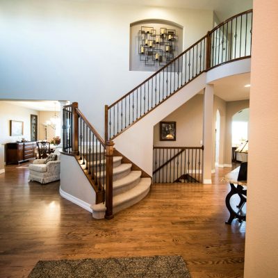 Spacious modern interior showcasing a stylish wooden staircase and elegant decor.